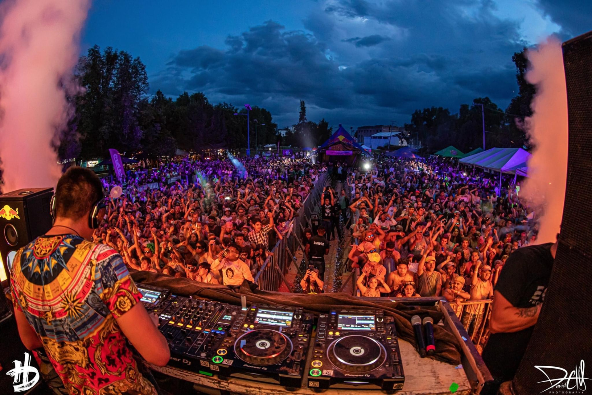 DJ mezclando frente a la multitud al atardecer